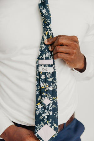 Rio tie worn with a white shirt, brown belt and blue pants.
