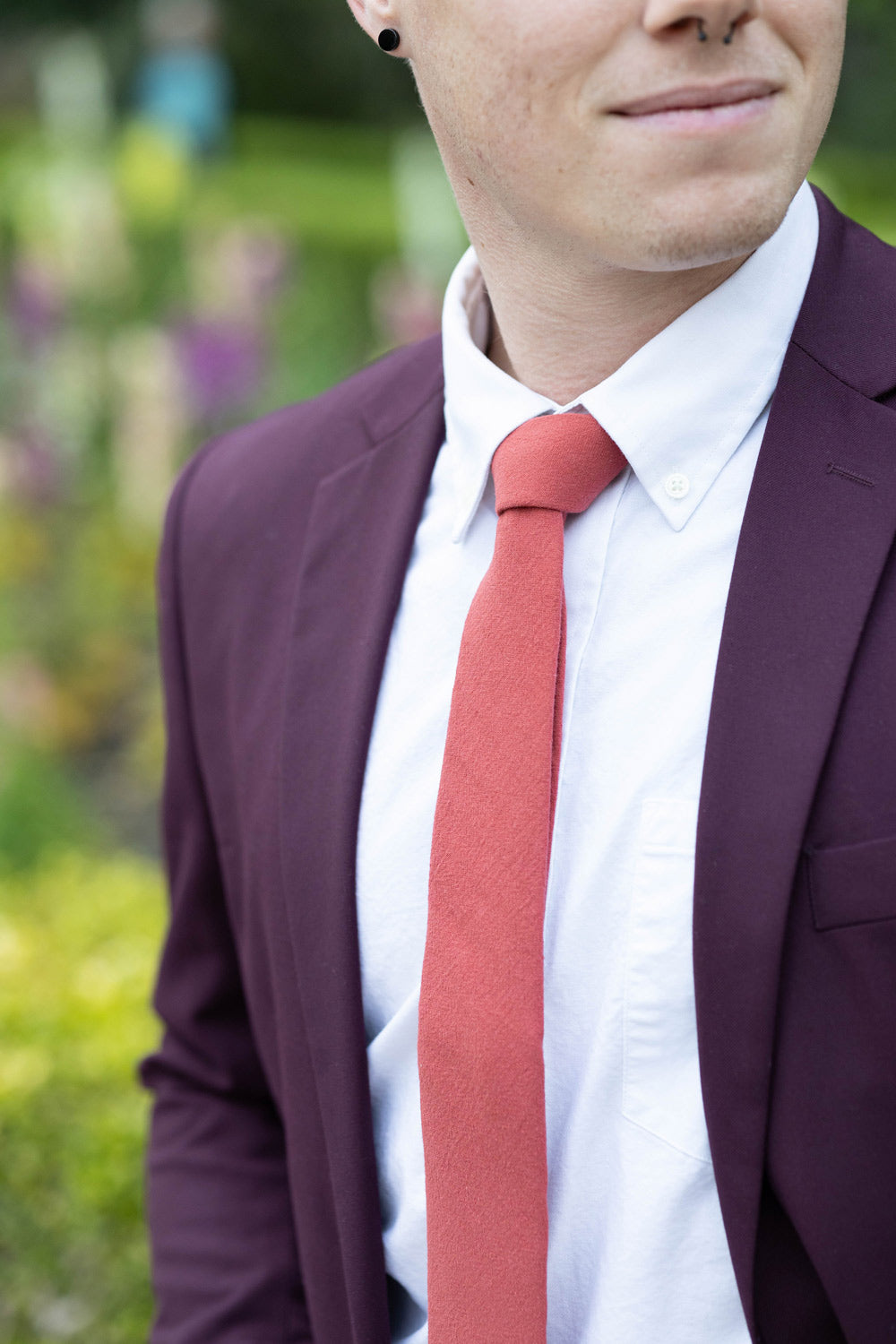 Spice necktie worn with a white shirt and plum purple suit. 