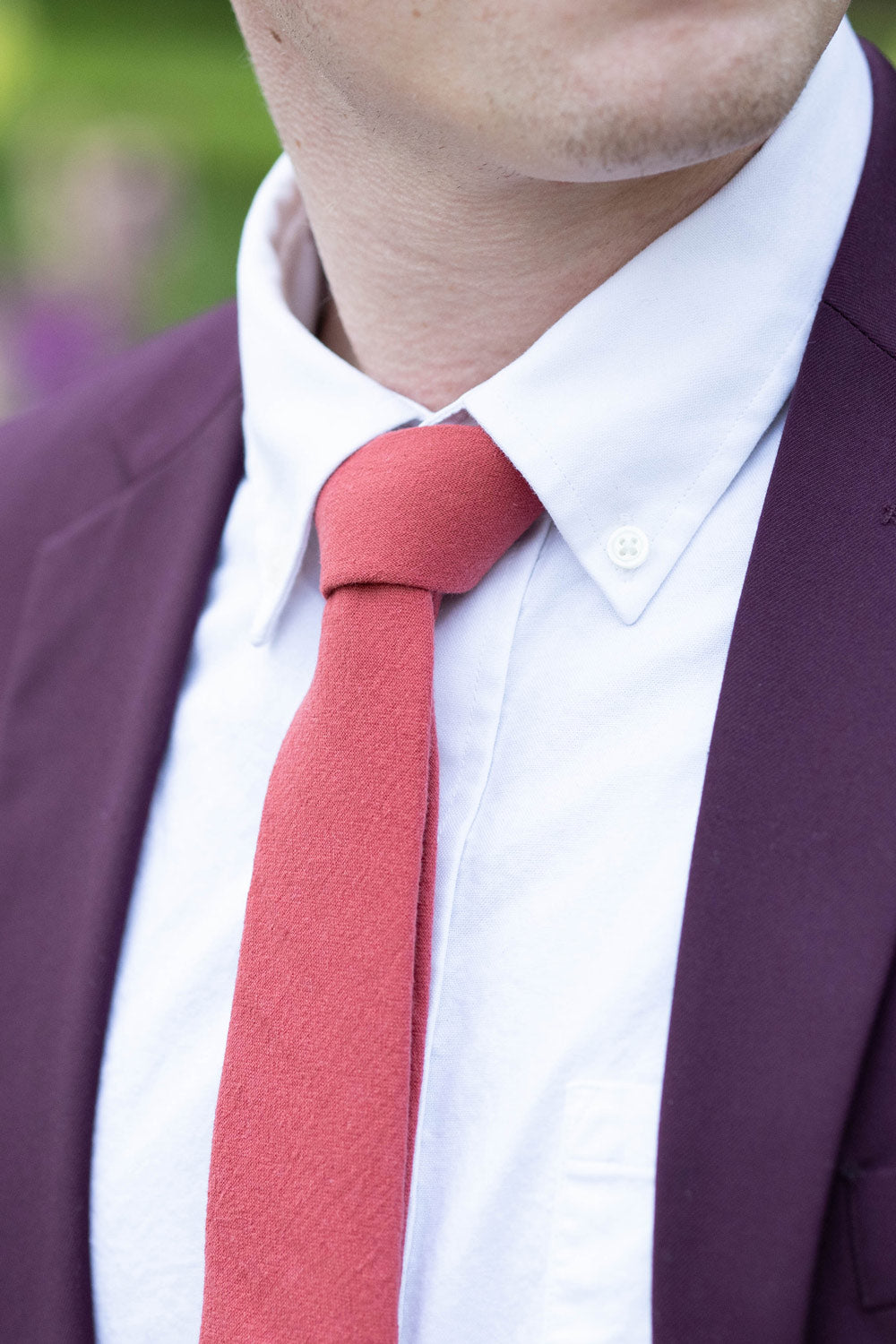 Spice necktie worn with a white shirt and plum purple suit. 