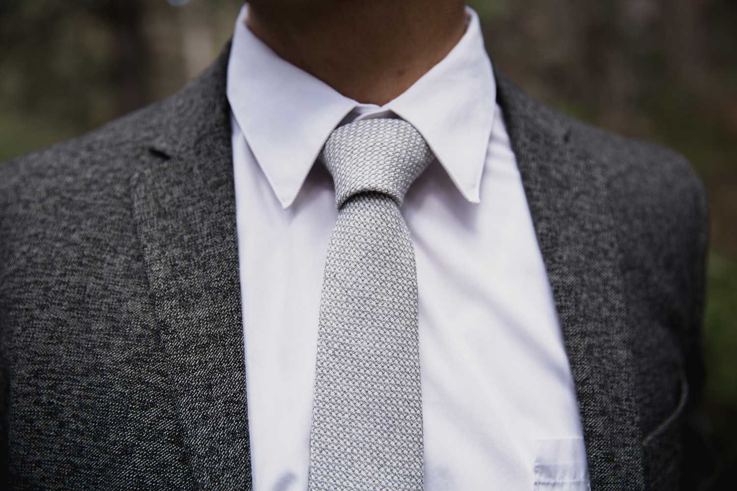 Calm tie worn with white shirt and textured charcoal gray suit jacket.