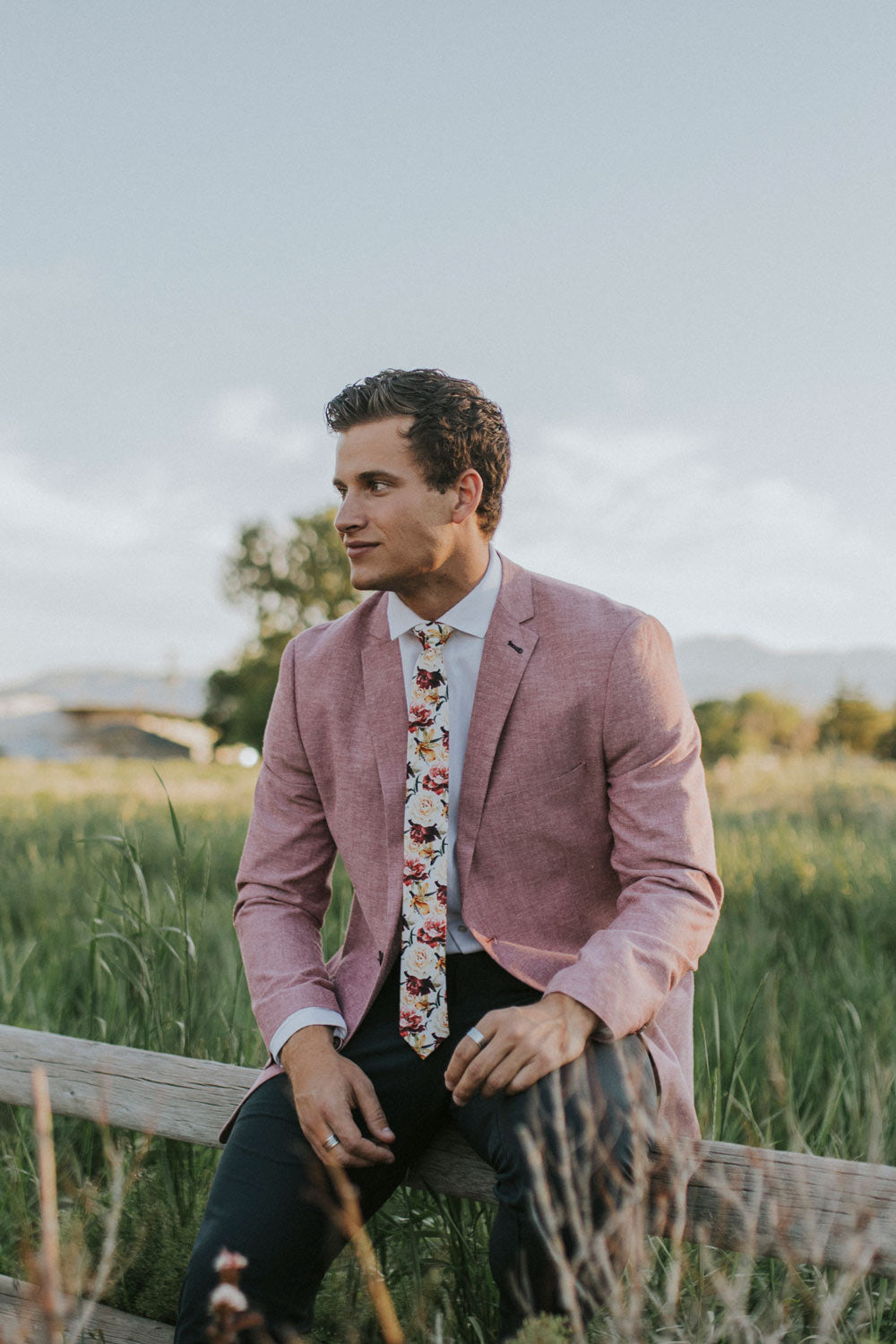 Coral Void tie worn with a white shirt, faded maroon suit jacket and black pants. 
