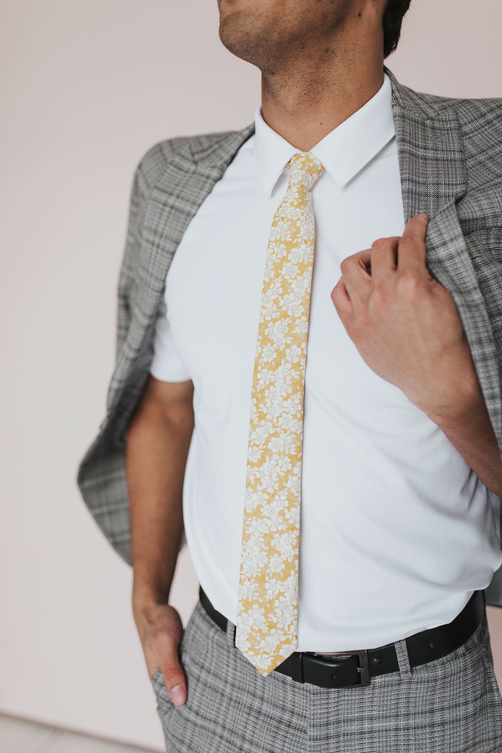 Daisy Tie worn with a white shirt and gray plaid suit.