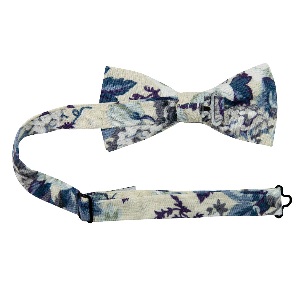 Dreamy Fields Pre-Tied Bow Tie with Adjustable Neck Strap. Cream background with dusty blue, white and gray flowers with navy blue and purple leaves.