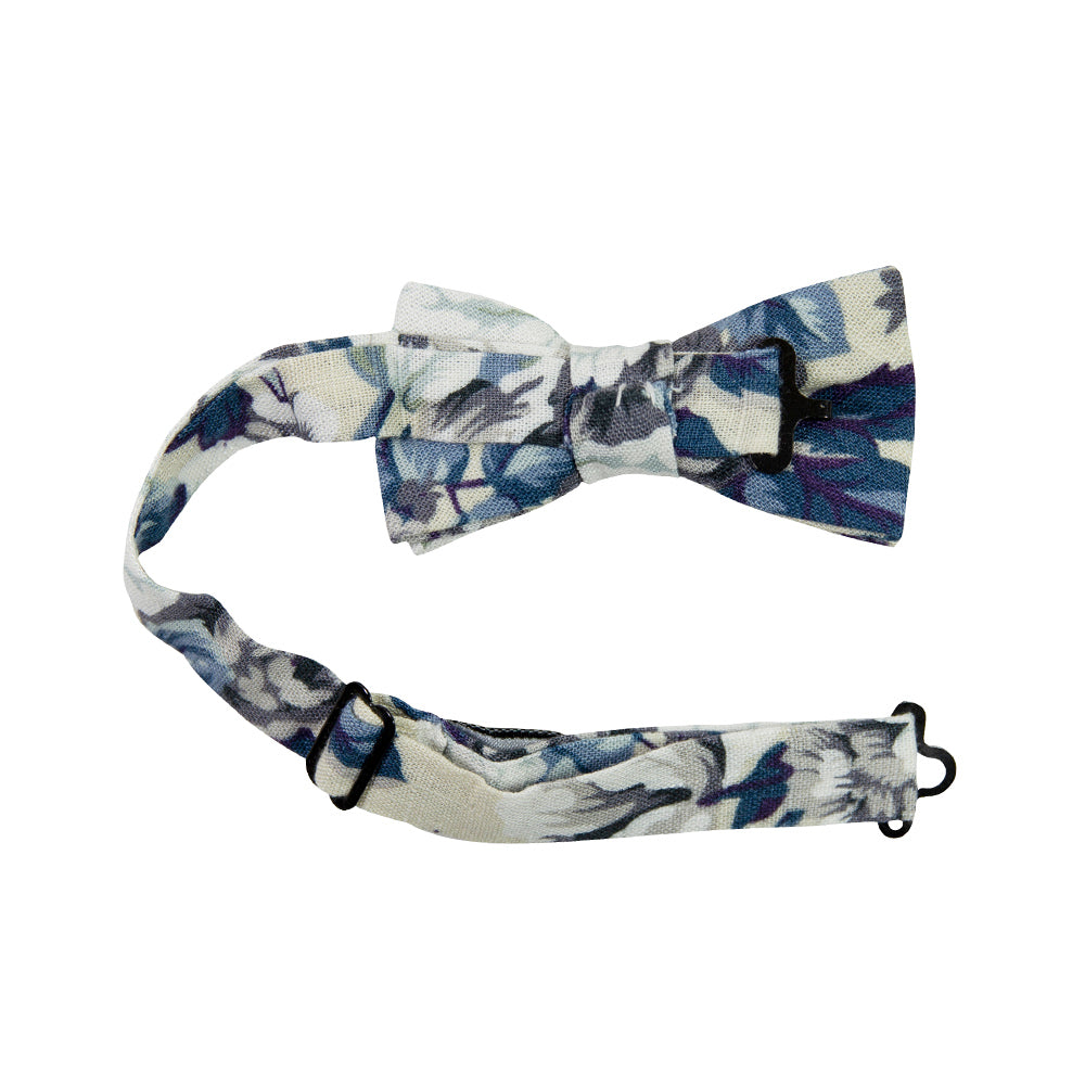 Dreamy Fields Pre-Tied Bow Tie with Adjustable Neck Strap. Cream background with dusty blue, white and gray flowers with navy blue and purple leaves.