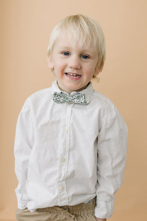 Hidden Garden pre-tied bow tie worn with a long sleeve white shirt and tan pants. 