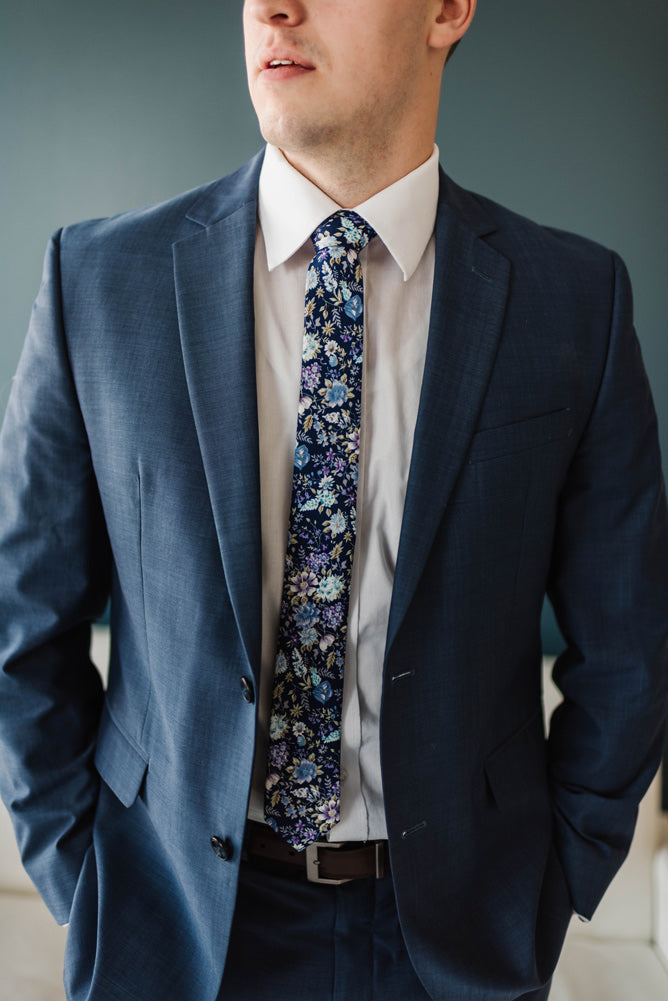 Lilac tie worn with a white shirt and blue suit.