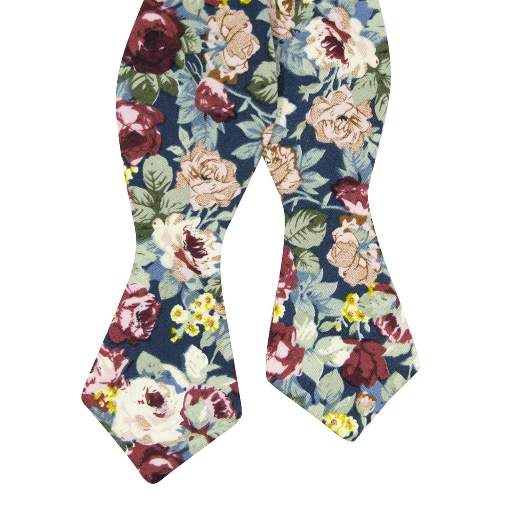 Mardi Self Tie Bow Tie. Navy background with yellow, red, and cream flowers and blue leaves.