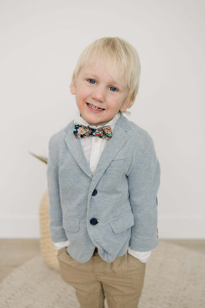 Mardi pre-tied bow tie worn by a young boy in a white shirt, gray blazer and tan pants. 