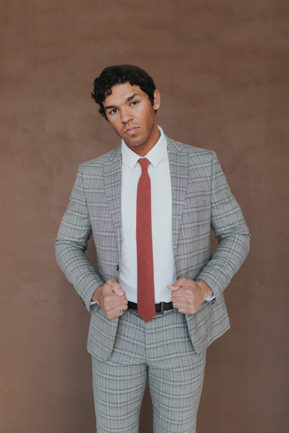 Rust Tie worn with a white shirt, black belt and gray plaid suit.