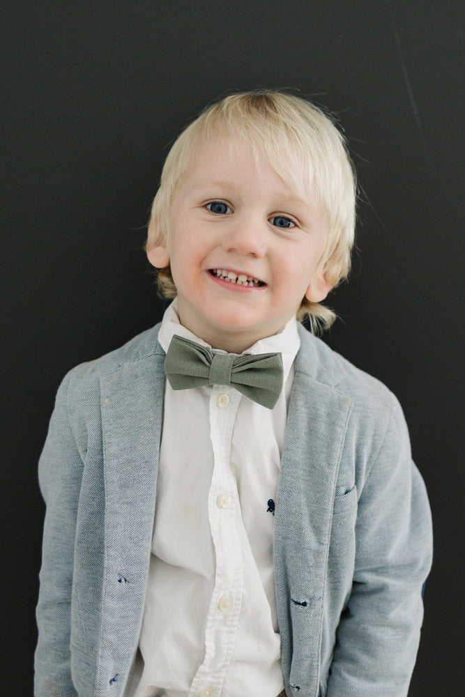 Sage pre-tied bow tie worn with a white shirt and gray blazer.