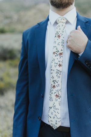 Sugar Blossom tie worn with a white shirt and blue suit jacket.