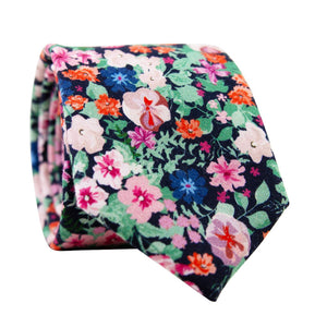 Abyss Skinny Tie. Dark navy blue background with a mix of pink, blue and orange flowers and green leaves.
