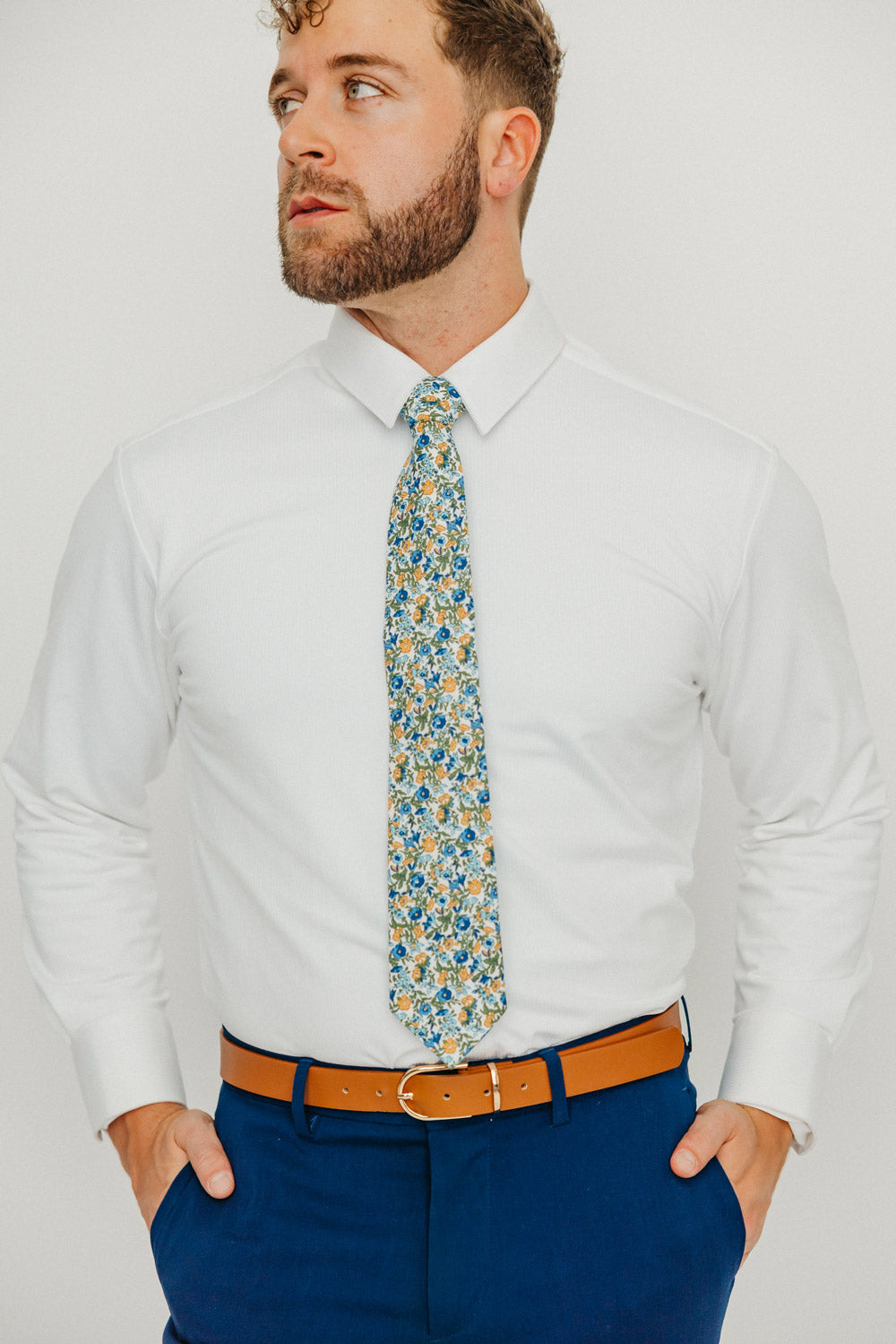 Alpine Blum tie worn with a white shirt, brown belt and blue pants.