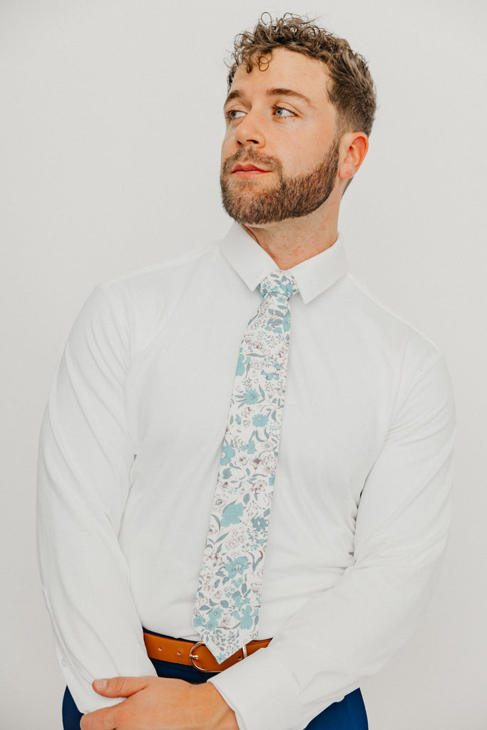 Baltic tie worn with a white shirt, brown belt and blue pants.