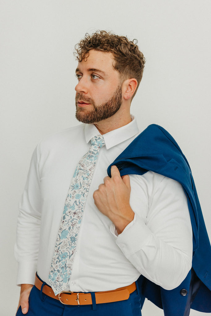 Baltic tie worn with a white shirt, brown belt and blue pants.