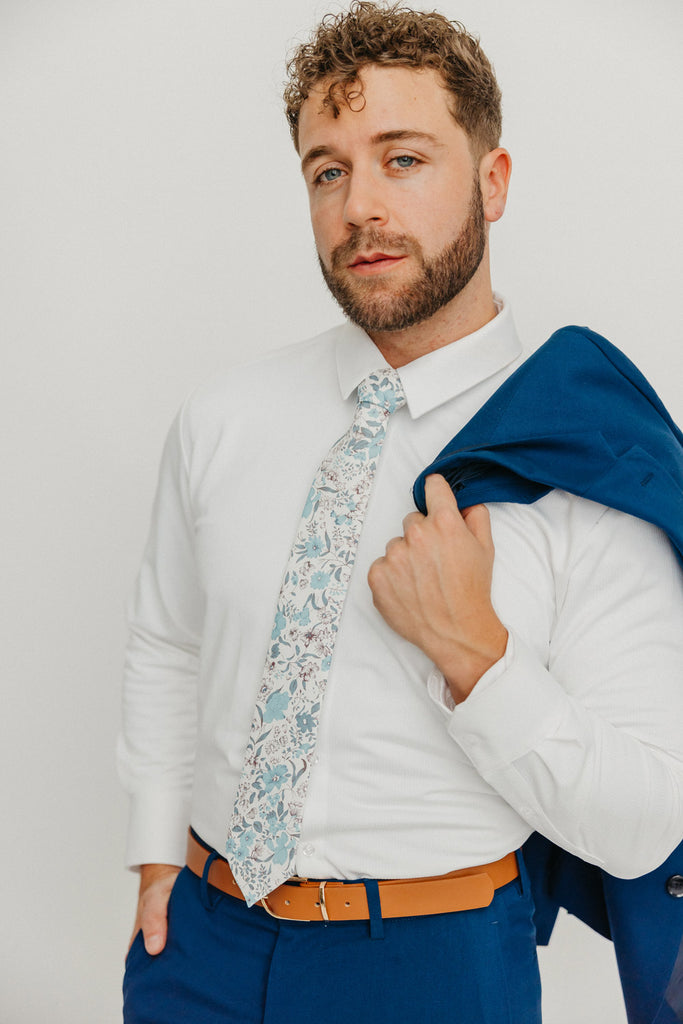 Baltic tie worn with a white shirt, brown belt and blue pants.