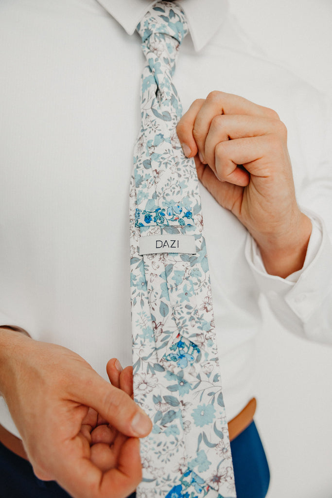 Baltic tie worn with a white shirt, brown belt and blue pants.