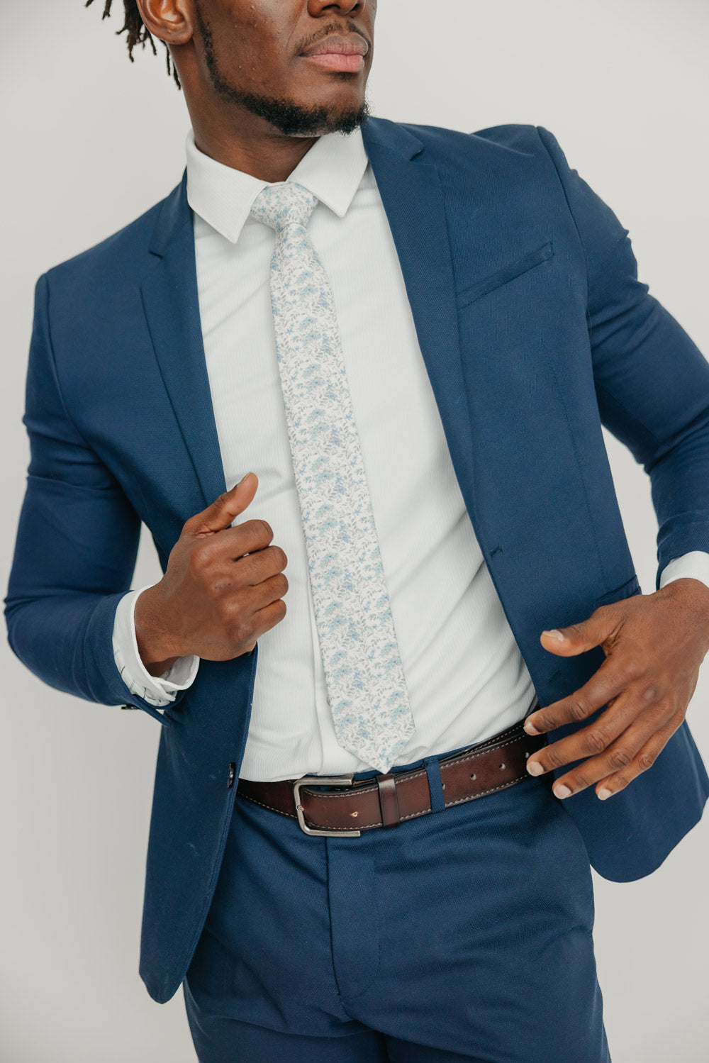 Bluebell tie worn with a white shirt, brown belt and blue suit.