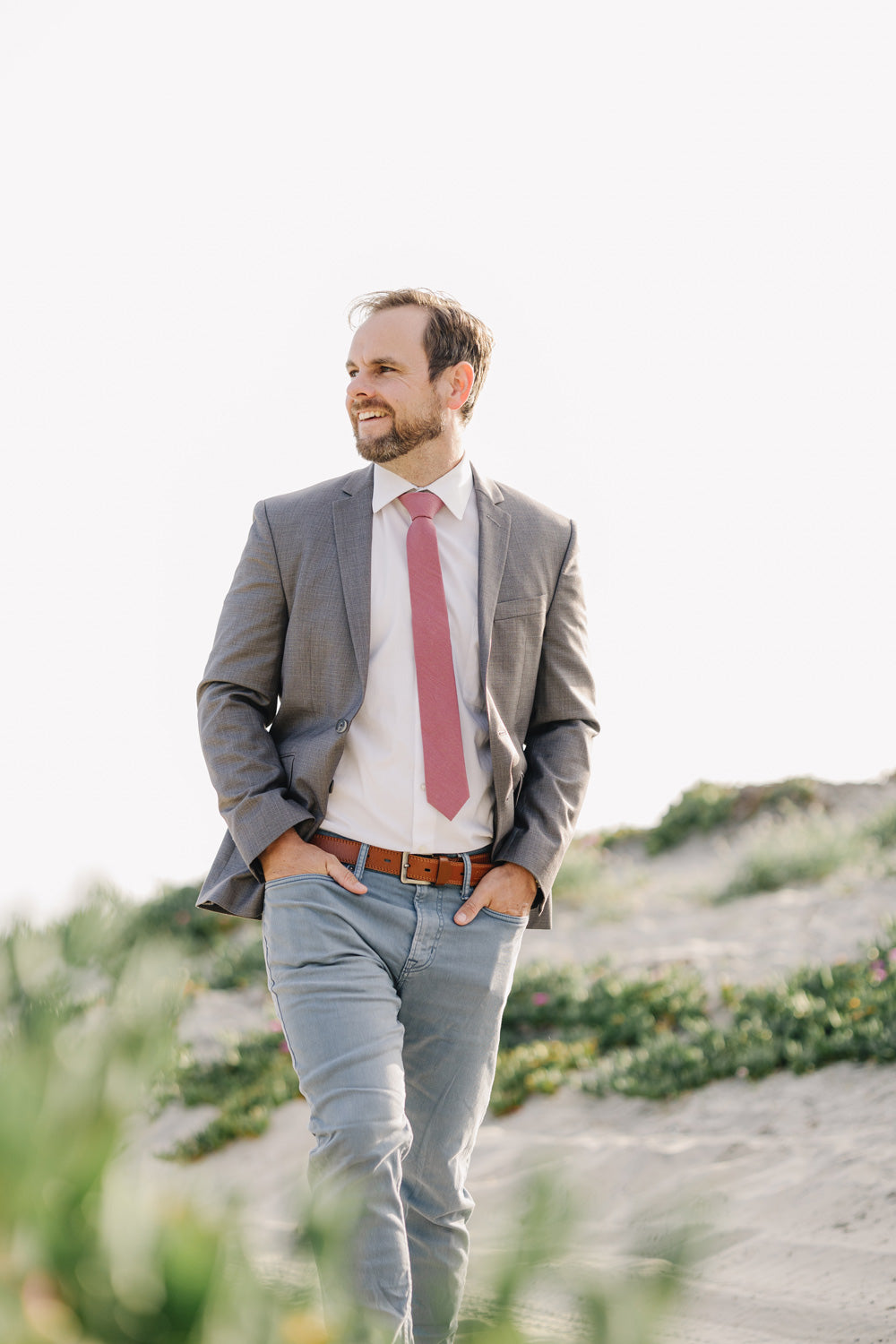 Dusty Rose Tie worn with a white shirt, gray suit jacket and blue pants.