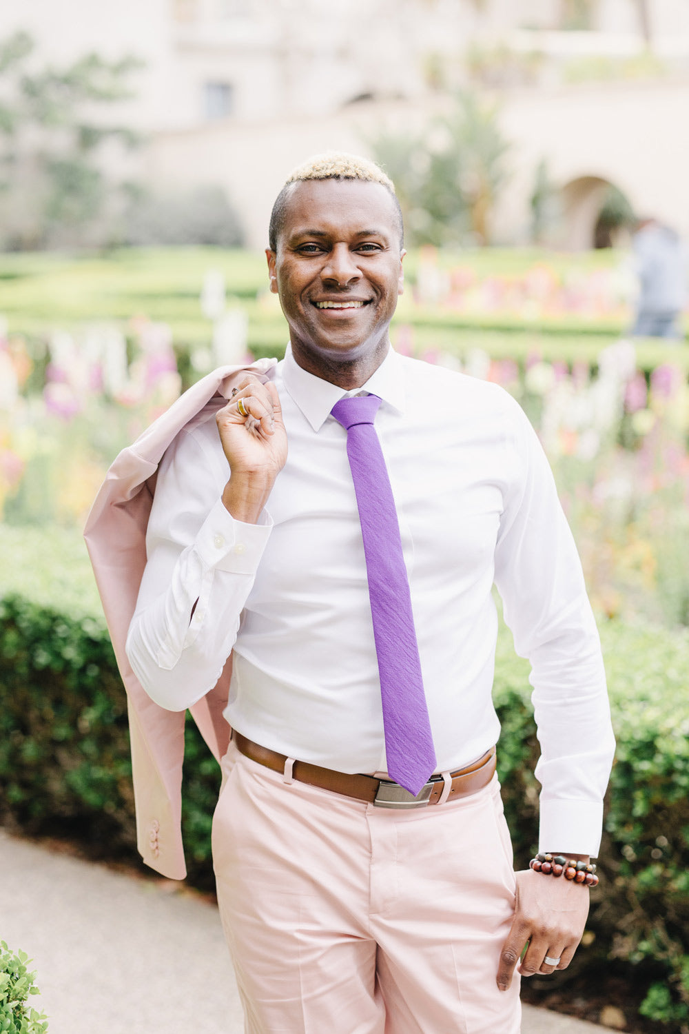 Grape tie worn with a white shirt and light pink suit.