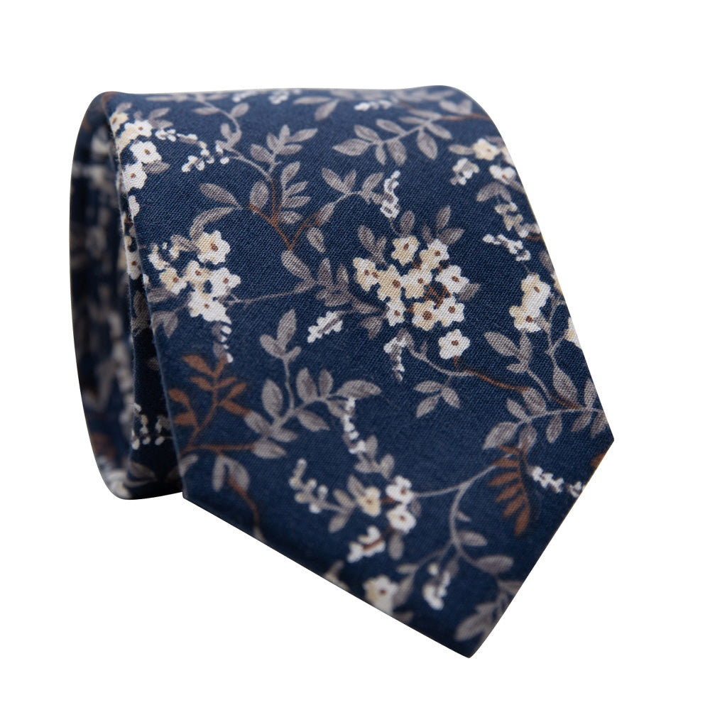Homestead Skinny Tie. Navy Blue background with small white and cream flowers and light brown and gray leaves and vines.