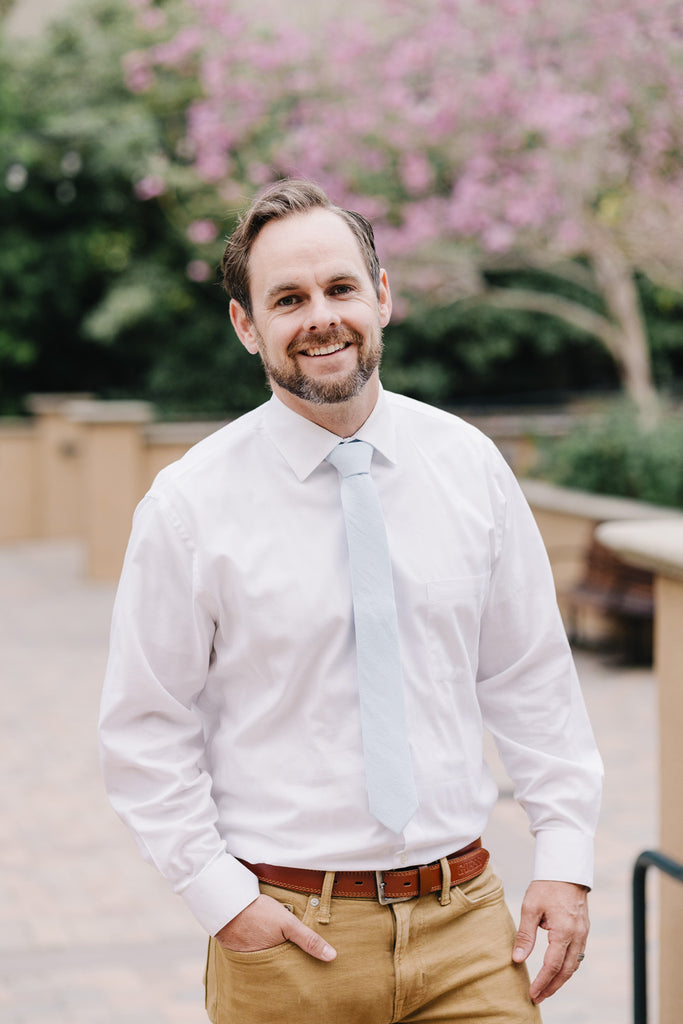 Ice Blue tie worn with a white shirt and tan pants.