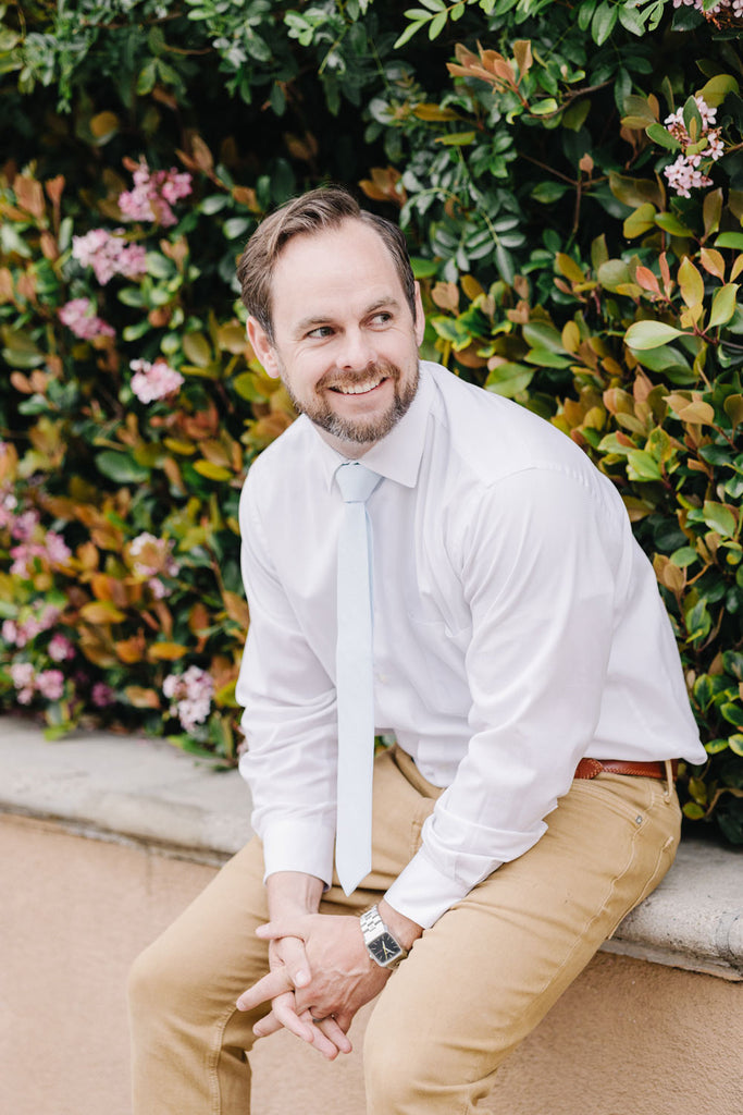 Ice Blue tie worn with a white shirt and tan pants.