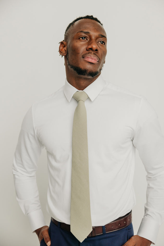 Light Sage tie worn with a white shirt, brown belt and blue pants.