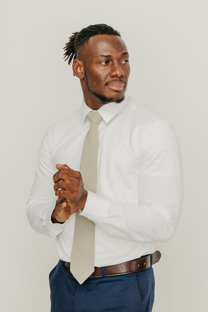 Light Sage tie worn with a white shirt, brown belt and blue pants.