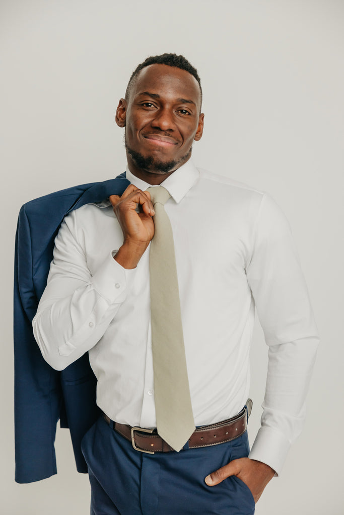 Light Sage tie worn with a white shirt, brown belt and blue pants.