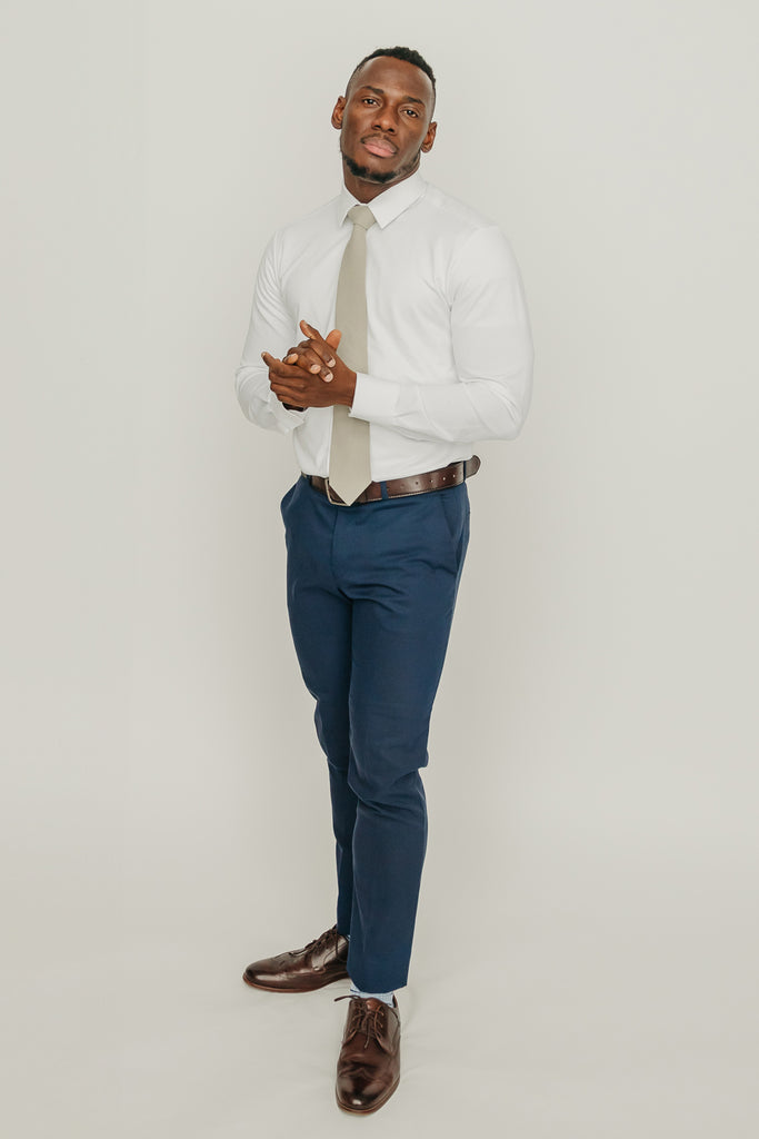 Light Sage tie worn with a white shirt, brown belt and blue pants.