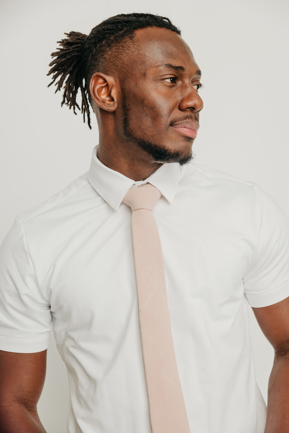 Mauve tie worn with a white shirt.