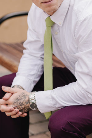 Moss tie worn with a white shirt and plum purple suit pants.