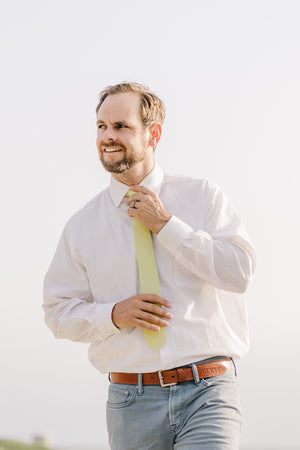 Pale Lime tie worn with a white shirt and blue pants.