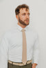 Sand tie worn with a white shirt, brown belt and olive green pants.
