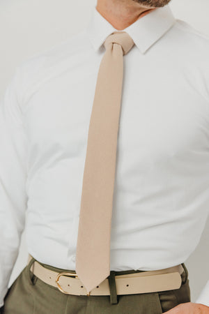 Sand tie worn with a white shirt, brown belt and olive green pants.