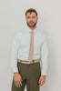 Sand tie worn with a white shirt, brown belt and olive green pants.