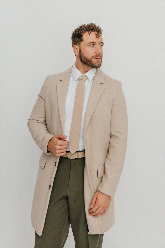 Sand tie worn with a white shirt, brown belt and olive green pants.