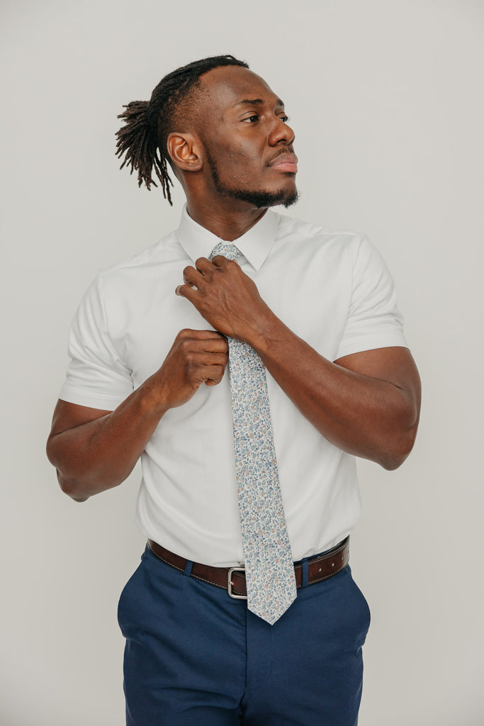 Scorpion Grass tie worn with a white shirt, brown belt and blue pants.