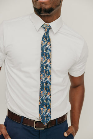 Tiger Lily tie worn with a white shirt, brown belt and blue pants.