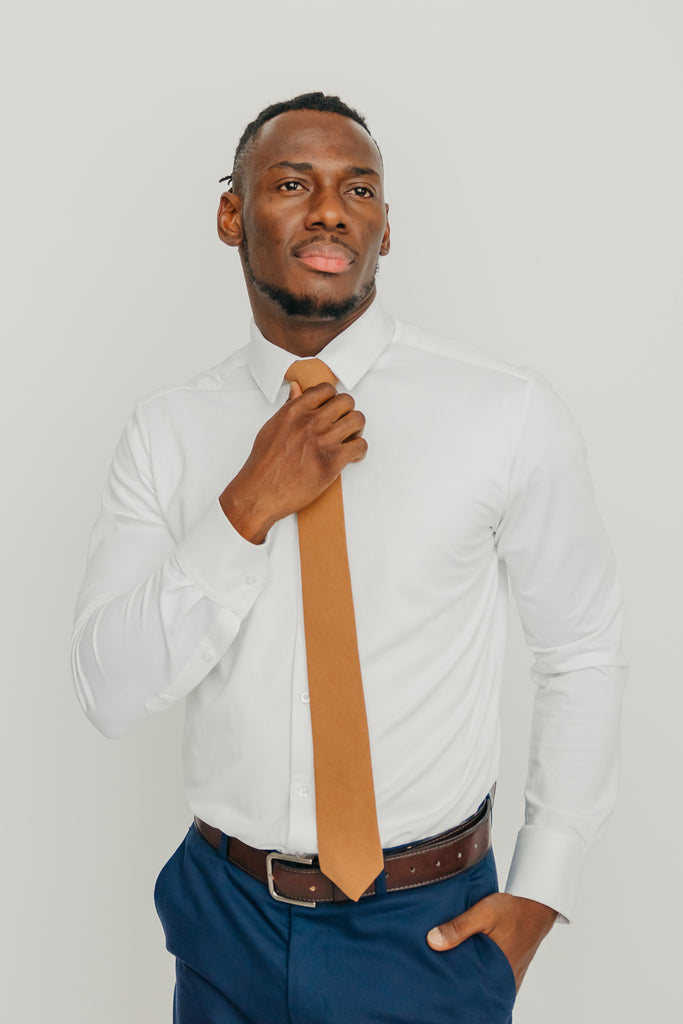 Timber tie worn with a white shirt, brown belt and blue pants.