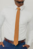 Timber tie worn with a white shirt, brown belt and blue pants.