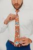 Western tie worn with a white shirt, brown belt and blue pants.