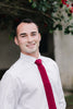Wine necktie worn with a white shirt.