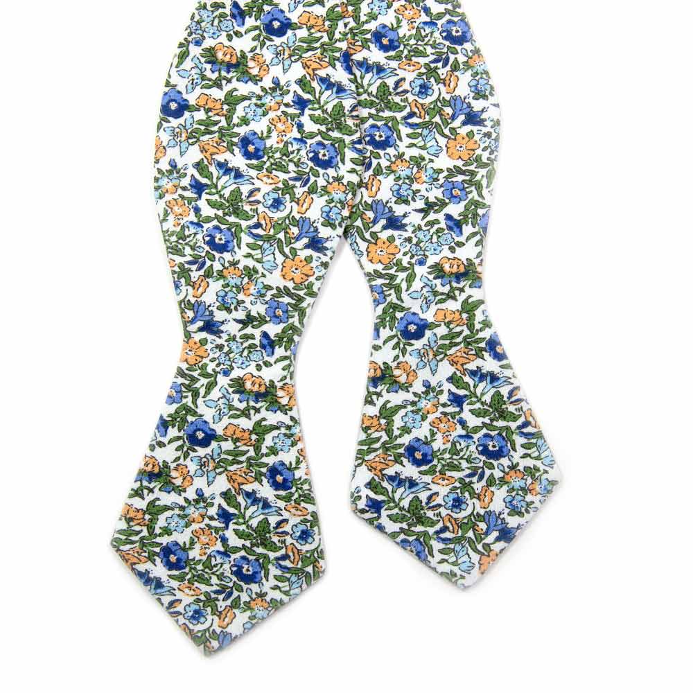 Alpine Blum Self Tie Bow Tie. White background with small blue and yellow flowers, small green leaves throughout.