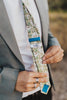 Alyssum tie worn with a white shirt, gray suit jacket, black belt and black pants. The backside with the DAZI logo tag is showing.