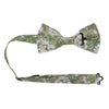 Alyssum Pre-Tied Bow Tie with adjustable neck strap. Light sage green background with medium white flowers and green leaves patterned throughout.