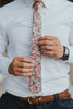 Bed of Roses tie worn with a white shirt, brown belt and blue pants.