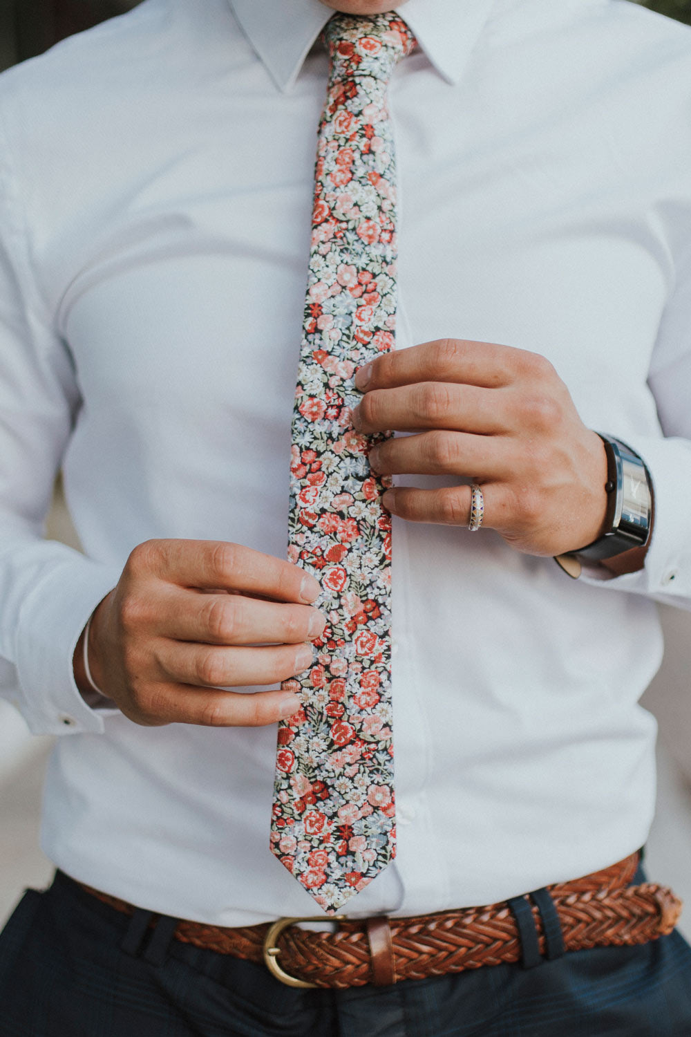 Bed of Roses tie worn with a white shirt, brown belt and blue pants.