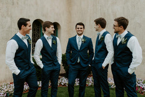 Dusty Bow Tie worn by four groomsmen wearing white shirts, navy vests and navy suit pants.